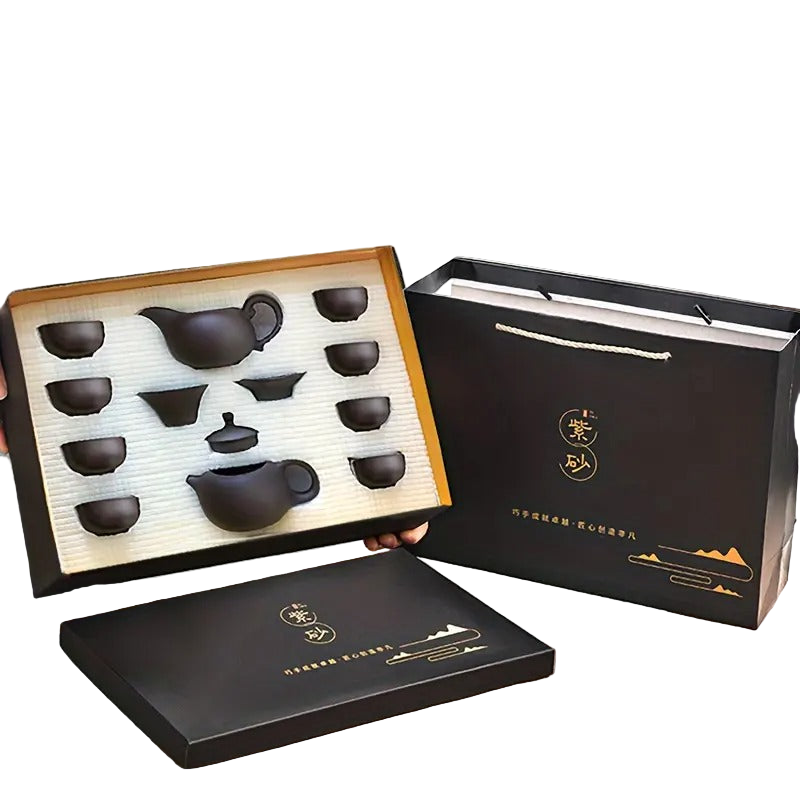 Tea set with black teapots and cups in a black box on a white background
