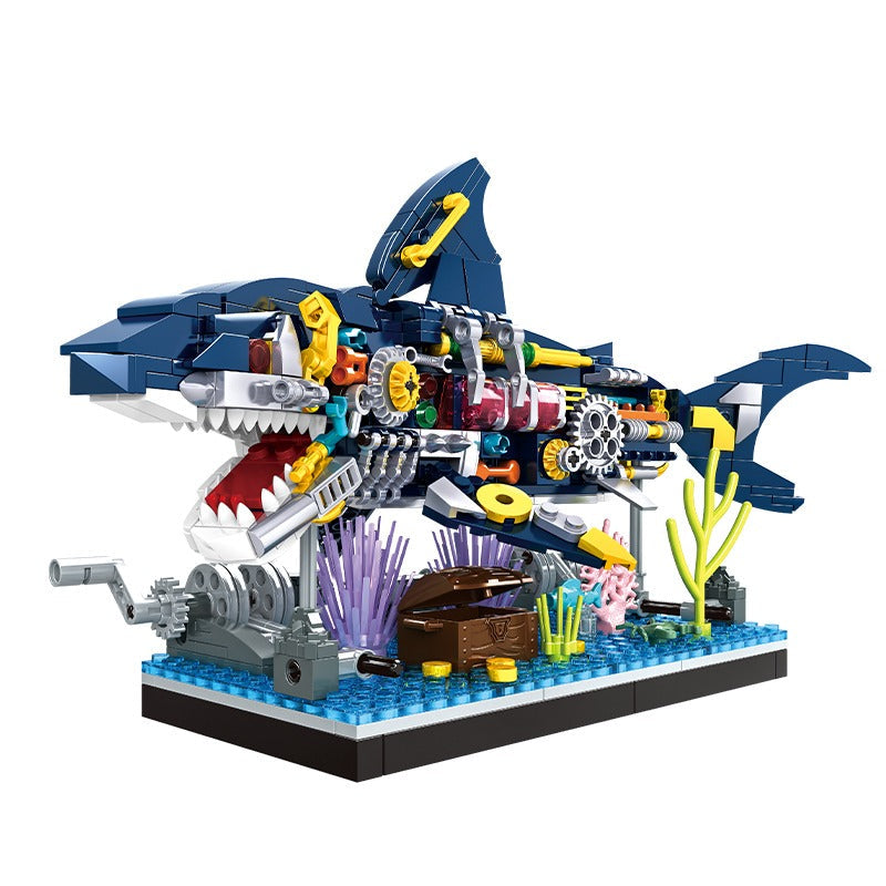 Toy shark model made of interlocking bricks with colorful details on a white background, featuring the Woma brand logo.