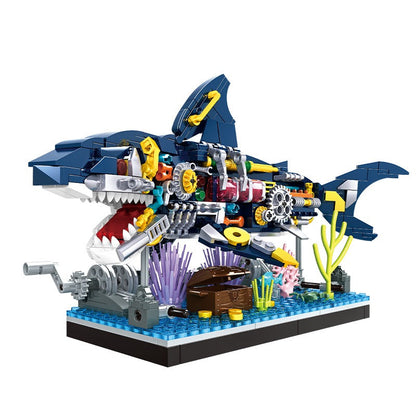 Toy shark model made of interlocking bricks with colorful details on a white background, featuring the Woma brand logo.